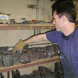 Cathouse Employee selecting iron mold casting from an inventory of over 200 castings